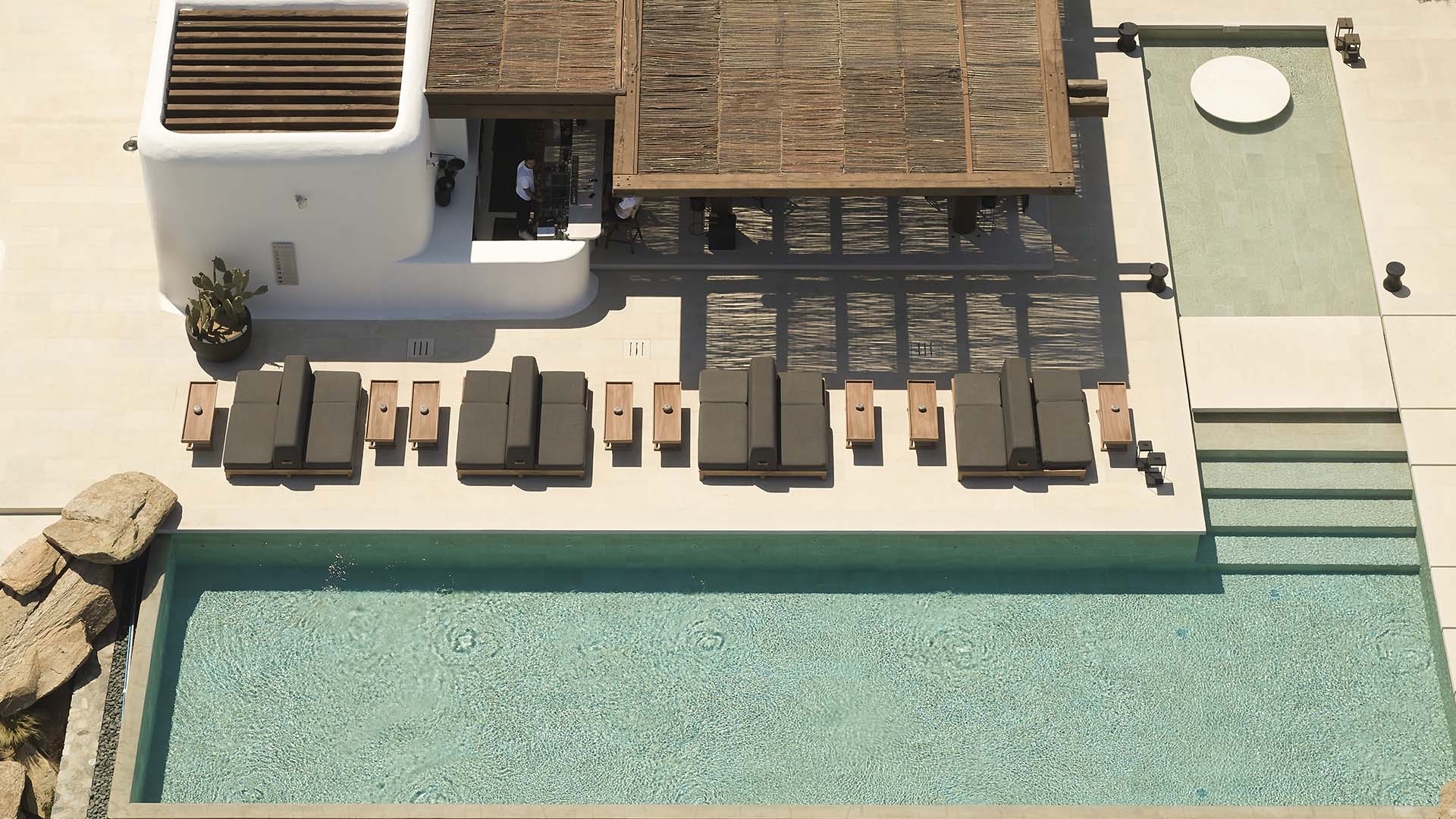 A tranquil poolside scene at Kalesma Hotel in Mykonos, inviting relaxation and enjoyment.