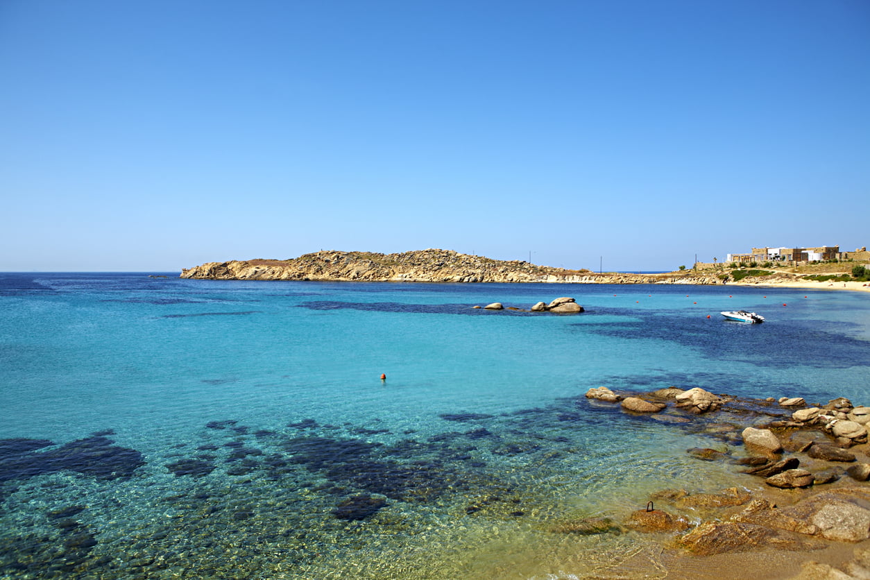 The tranquil waters of Paraga Beach in Mykonos invite a quiet escape beneath the clear blue sky.