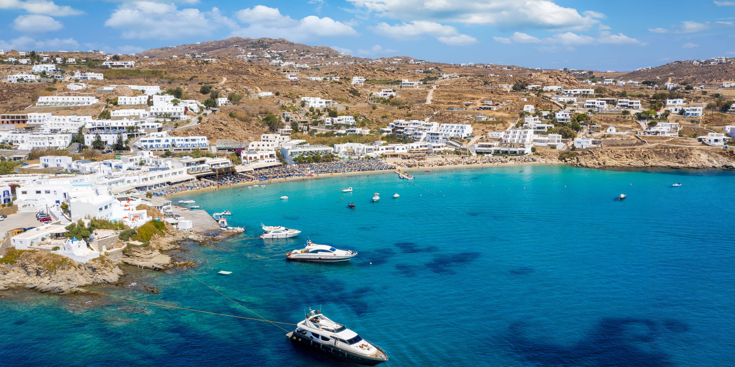 A serene view of Platys Gialos Beach in Mykonos, where the coastal vibe is as inviting as the clear blue sea.