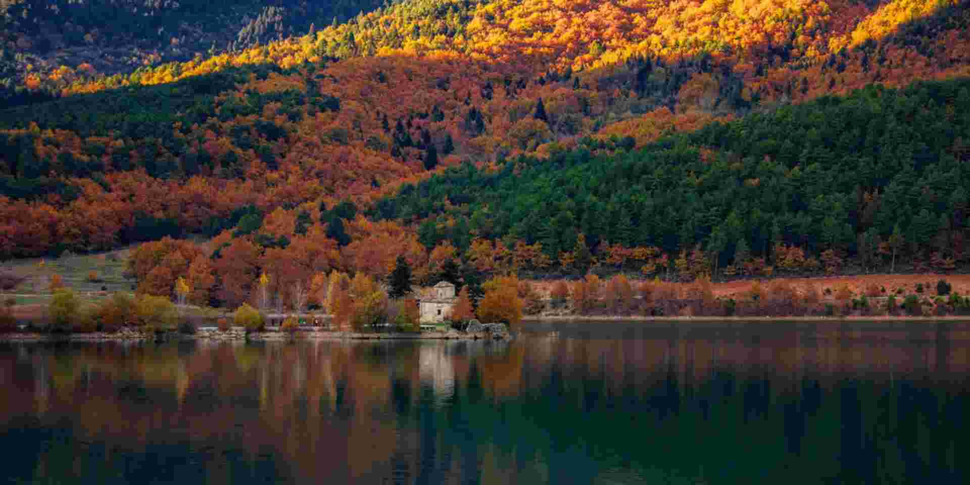 View of Doxa Lake (or Feneos) in autumn with the small church of St. Fanourios on an islet. Doxa lake is an artificial lake in western Corinthia, Peloponnese Greece. It is fed and drained by the small river Doxa, which empties into the plain of Feneos_Greek lake vacation Lake Doxa_Feature_Greek lake vacation
