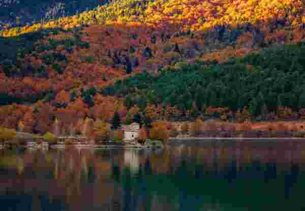 View of Doxa Lake (or Feneos) in autumn with the small church of St. Fanourios on an islet. Doxa lake is an artificial lake in western Corinthia, Peloponnese Greece. It is fed and drained by the small river Doxa, which empties into the plain of Feneos_Greek lake vacation Lake Doxa_Feature_Greek lake vacation