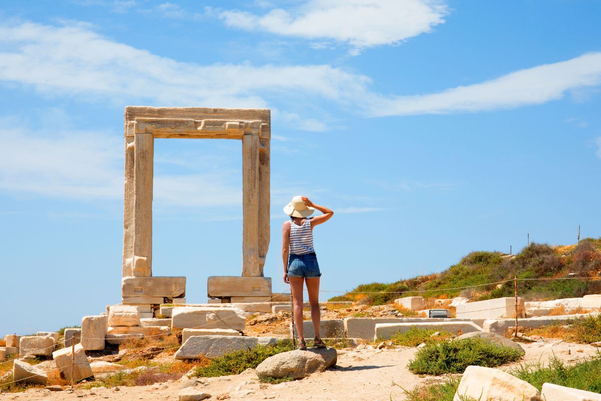 Greece , cyclades islands, Naxos Island. female tourist looking at Temple of Apollo mid day