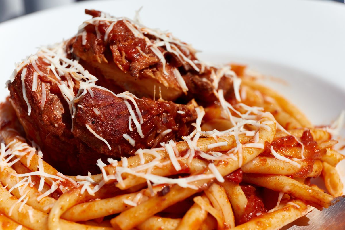 Freshly served in the restaurant pastitsada of beef with bucatini pasta. The most famous and characteristic dish from the island of Corfu in Greece.