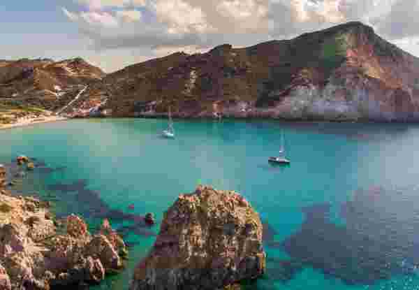 Crystal clear water in calm bay of Milos island is very attractive for sailboats and yachts milos island beach_feature