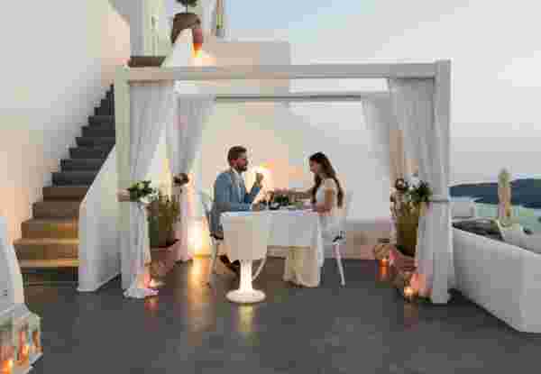 couple having candlelight dinner on romantic terrace with seaview honeymoon, vacation santorini honeymoon_feature