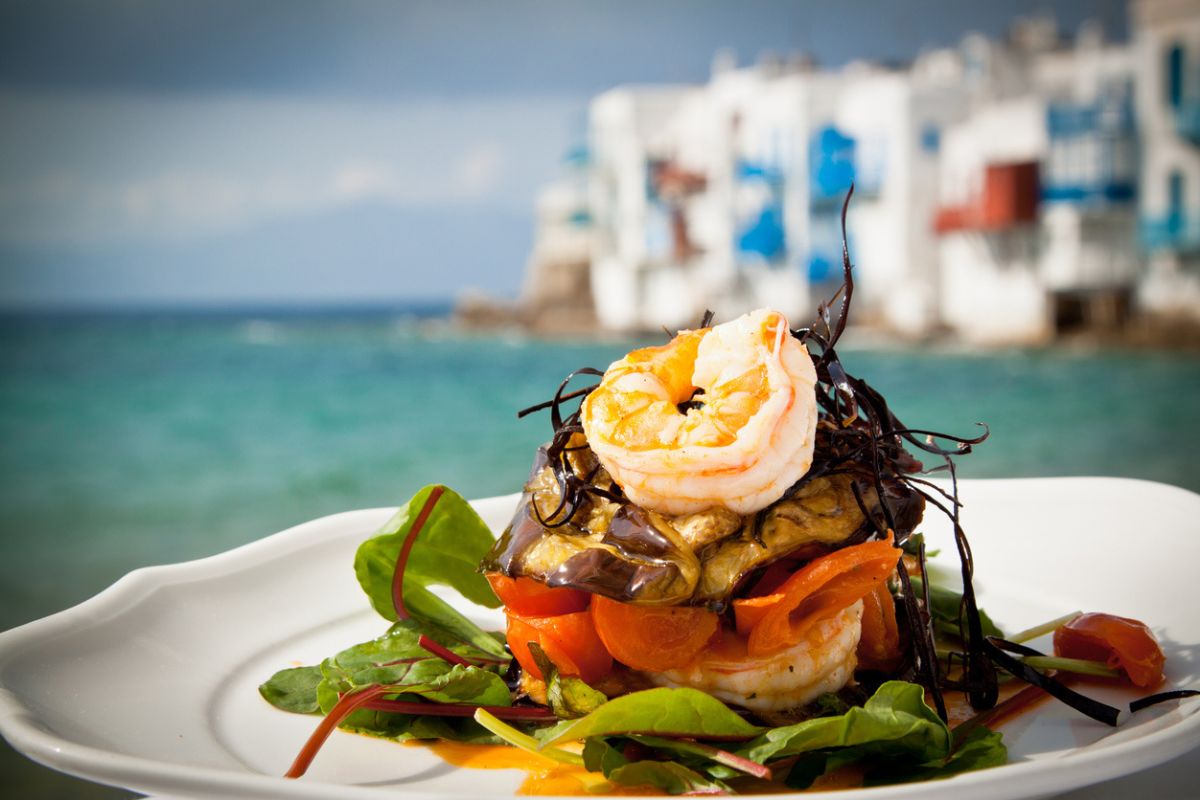 Prawn starter with aubergine, tomato and salad by the sea in Mykonos, Greece.