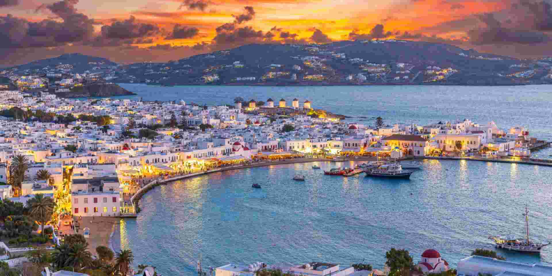 Embrace the warm hues of sunset in Mykonos Town Chora, where the Aegean Sea's azure waters reflect the vibrant life of this iconic Greek island_Greece Islands October Mykonos town_Greece Islands October_feature