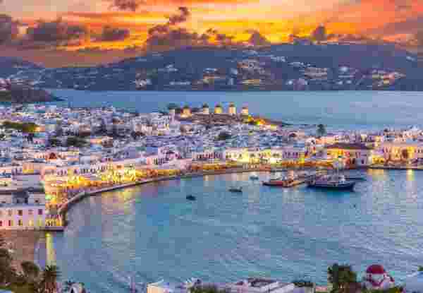 Embrace the warm hues of sunset in Mykonos Town Chora, where the Aegean Sea's azure waters reflect the vibrant life of this iconic Greek island_Greece Islands October Mykonos town_Greece Islands October_feature