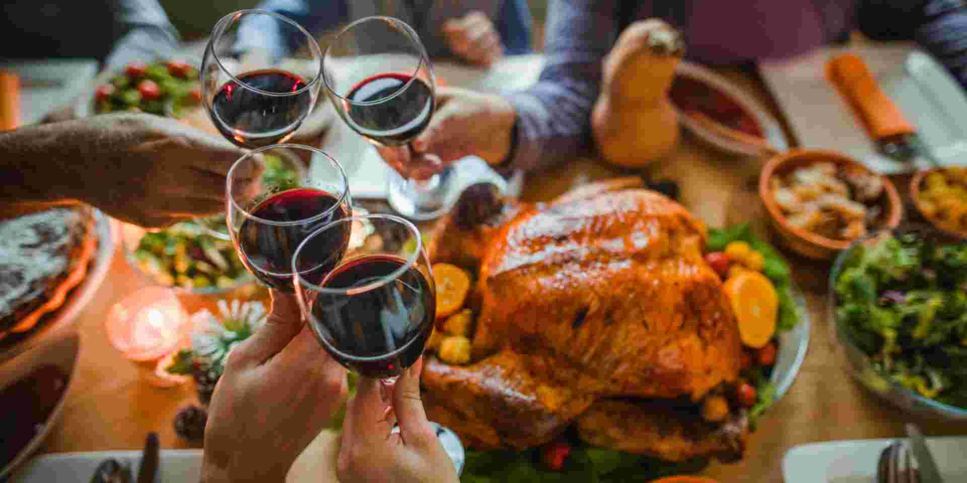 Group of unrecognizable people toasting with wine during Thanksgiving dinner at dining table. Greek christmas food_feature