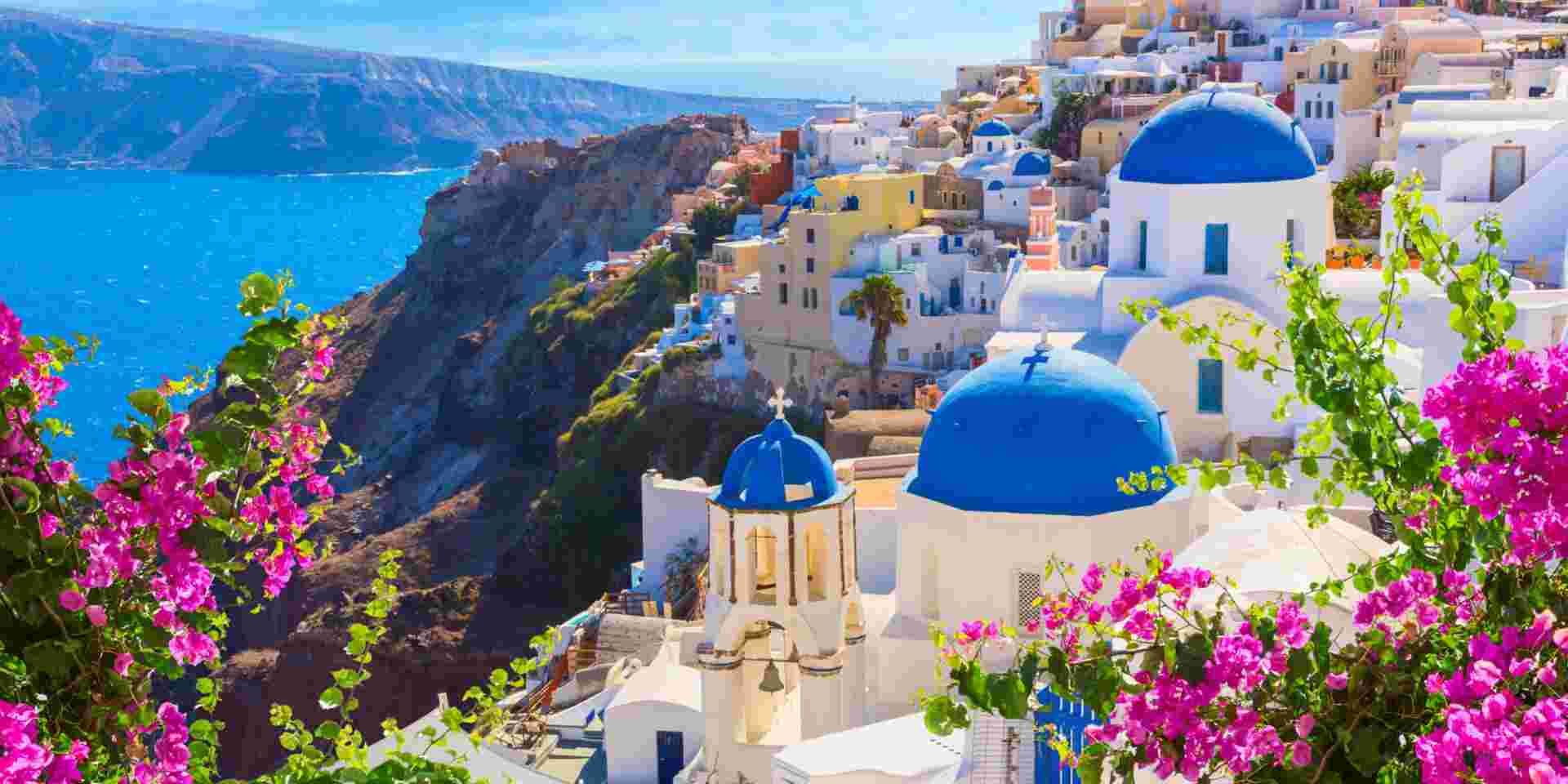 Santorini island, Greece. Oia town traditional white houses and churches with blue domes over the Caldera, Aegean sea. best things to do in santorini_feature