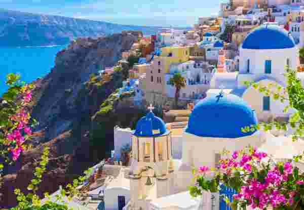 Santorini island, Greece. Oia town traditional white houses and churches with blue domes over the Caldera, Aegean sea. best things to do in santorini_feature