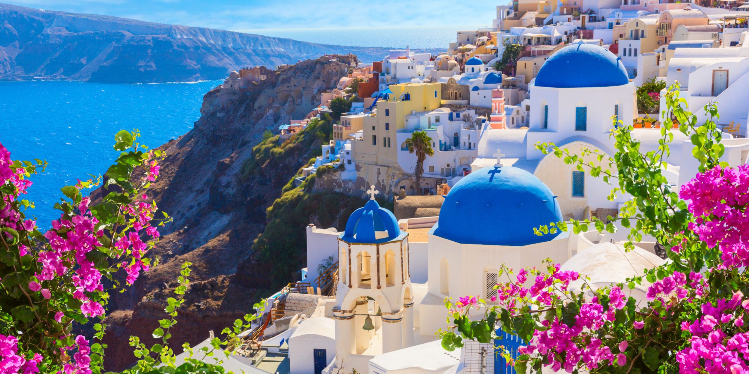 Santorini island, Greece. Oia town traditional white houses and churches with blue domes over the Caldera, Aegean sea.