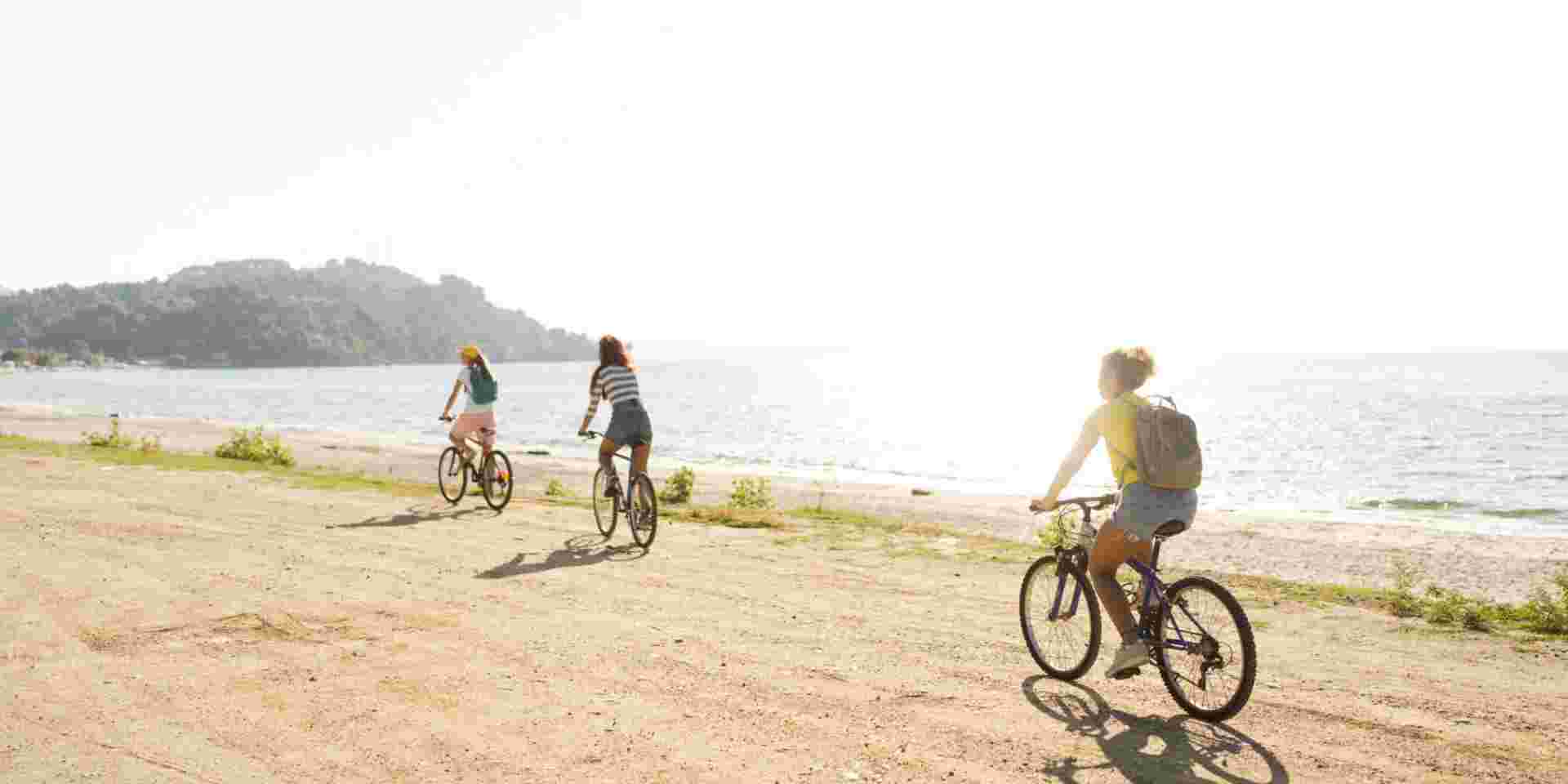 Photo of a smiling teenage girls, using bicycles to commute to the beach greece with kids guide_feature