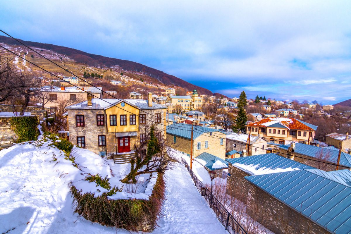 View of traditional stone buildings and streets with snow at the famous village of Nymfaio near Florina, Greece. 