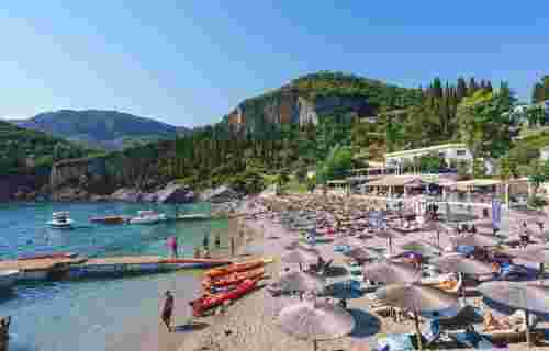 Liapades Beach with relaxing people in Palaiokastritsa Corfu Greece