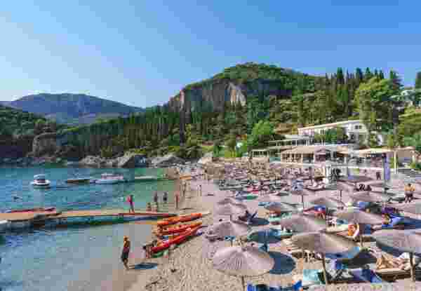Liapades Beach with relaxing people in Palaiokastritsa Corfu Greece
