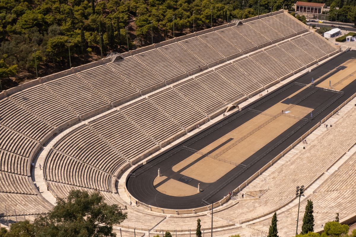 Panathenaic Stadium in Athens, Greece, historic marble stadium and iconic Olympic site surrounded by trees.