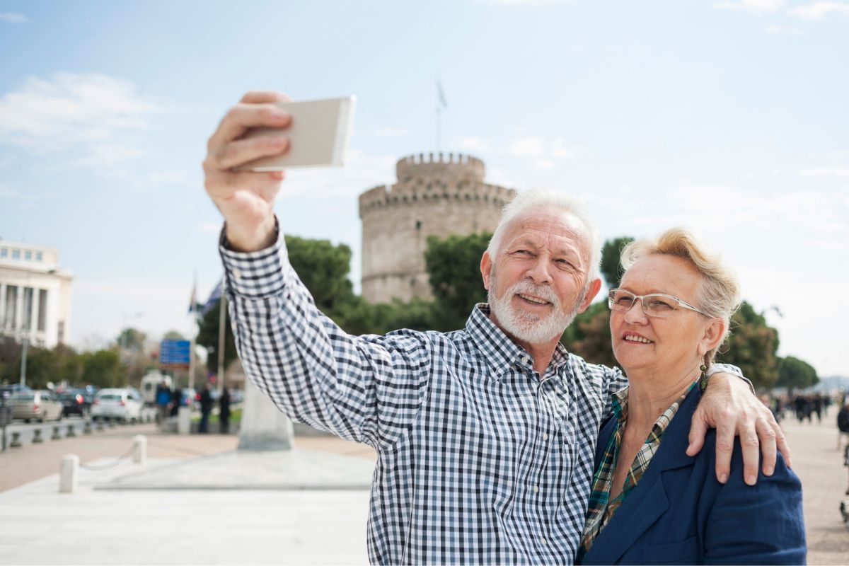 Senior couple making selfie in front of White Tower in Thessaloniki-Greece