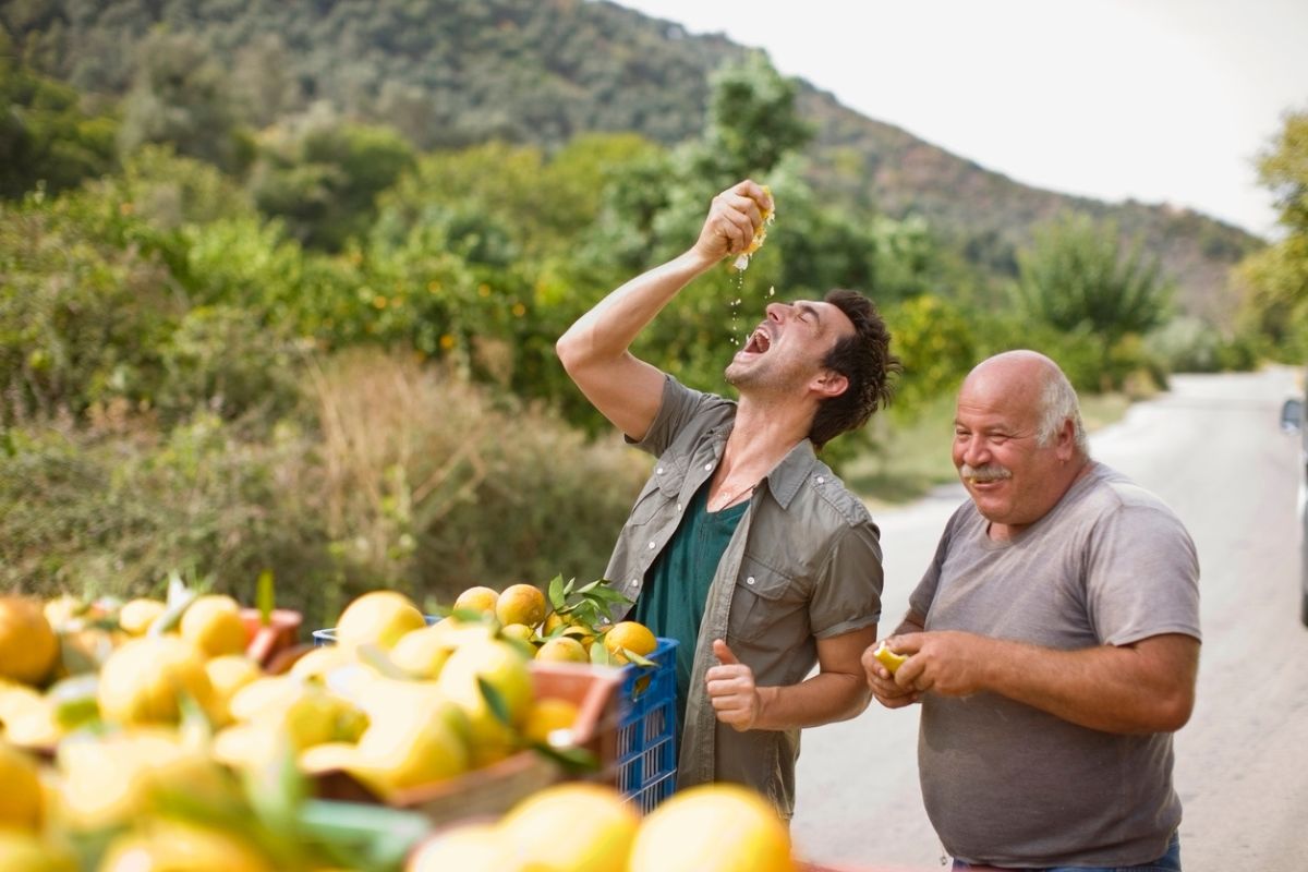 Men squashing oranges.