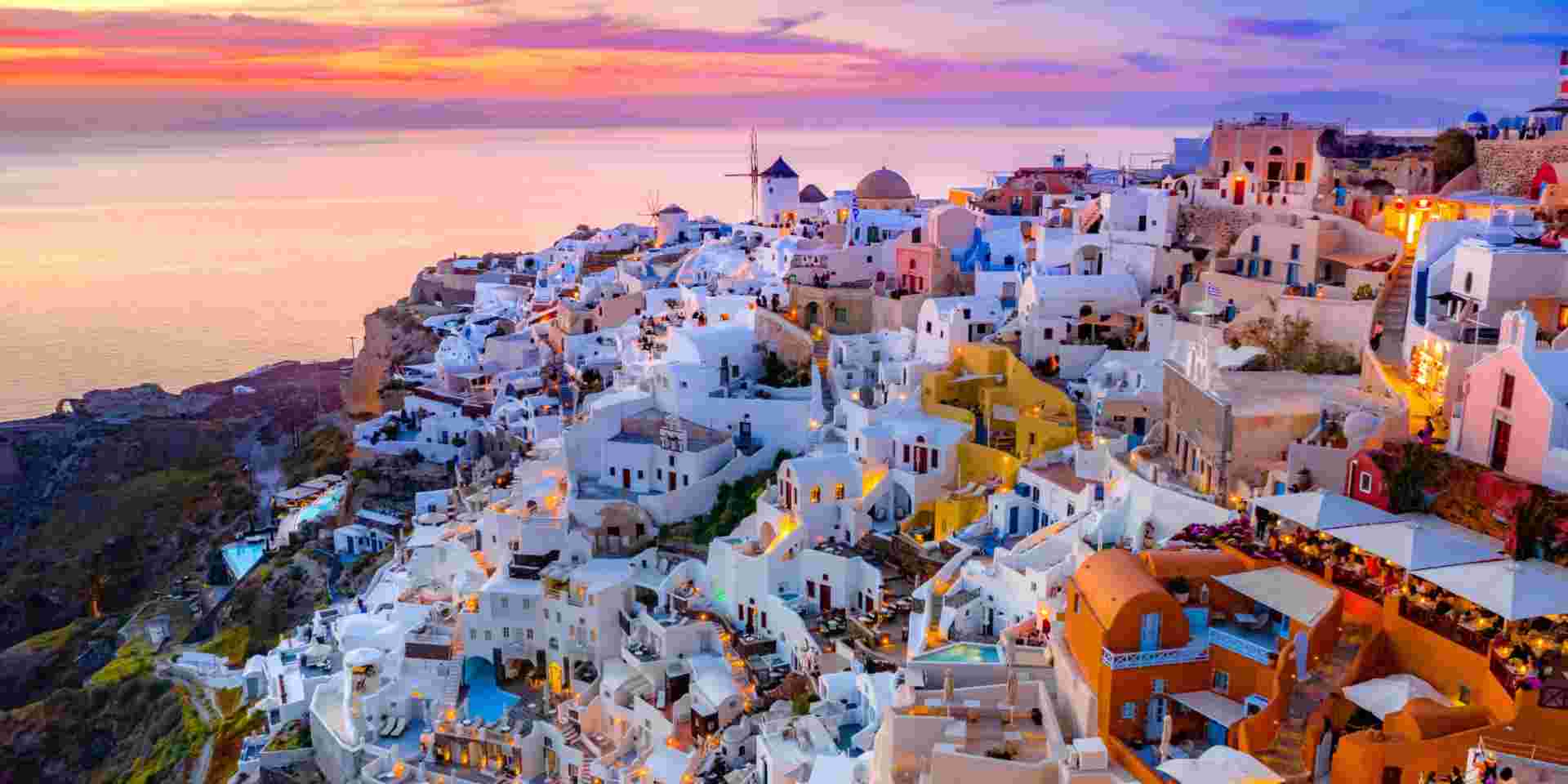 Oia town on Santorini island, Greece. Traditional and famous houses and churches with blue domes over the Caldera, Aegean sea what to do in santorini_feature