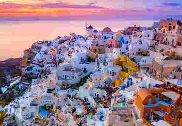 Oia town on Santorini island, Greece. Traditional and famous houses and churches with blue domes over the Caldera, Aegean sea what to do in santorini_feature