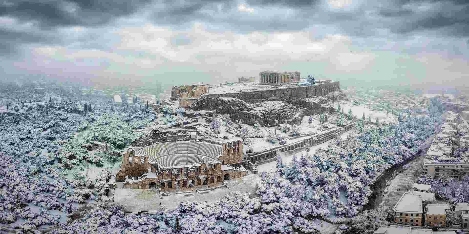 The Parthenon Temple and the Herodion Theater at the Acropolis of Athens, Greece, with ice and snow during a winter snowstorm athens winter_weather in janurary in greece_feature