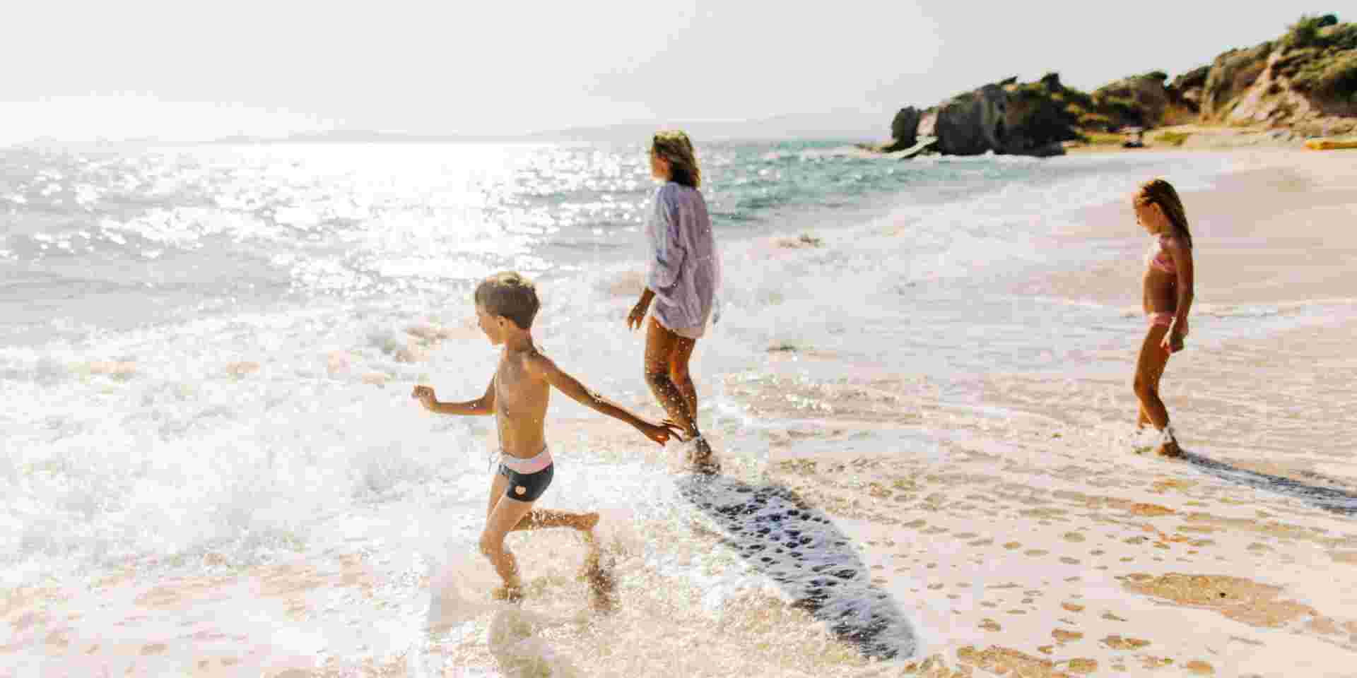 Photo of mother and her kids, enjoying together at the beach best greek islands for families_feature