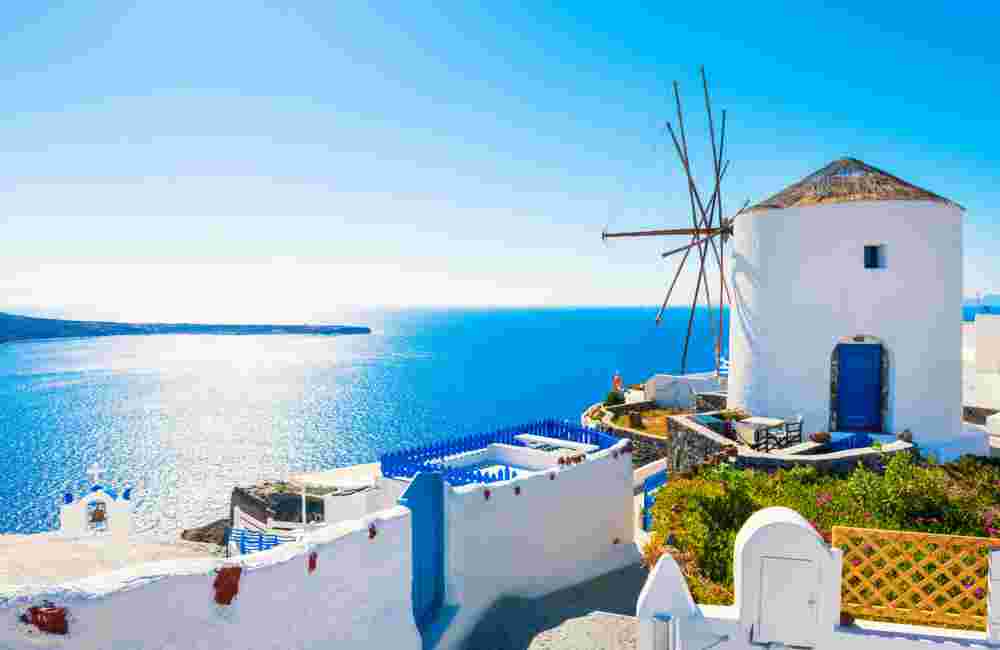 White architecture in Santorini island, Greece. Windmill in Oia town at sunny day.