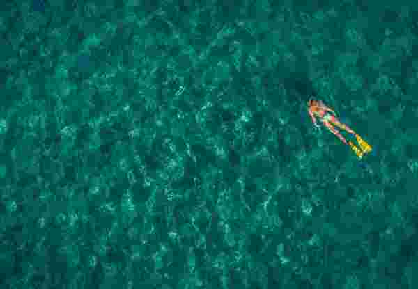 High angle view photo of a young woman diving and exploring wonderful underwater world, by using her diving equipment; wide photo dimensions snorkeling in greece_feature