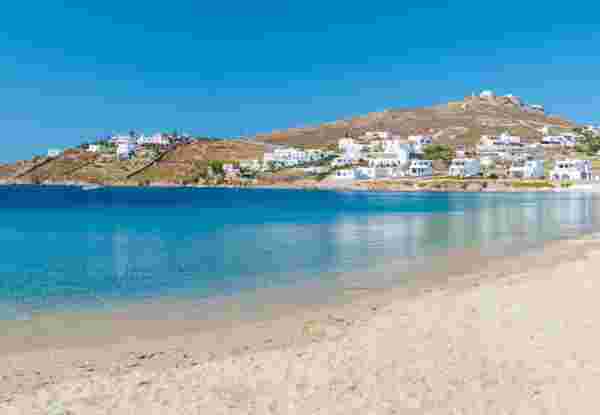 Mykonos beach during summer with umbrella and luxury beach chairs beds, blue ocean with the mountain at Elia beach Mikonos Greece. elia beach mykonos_nudist beaches in greece_feature