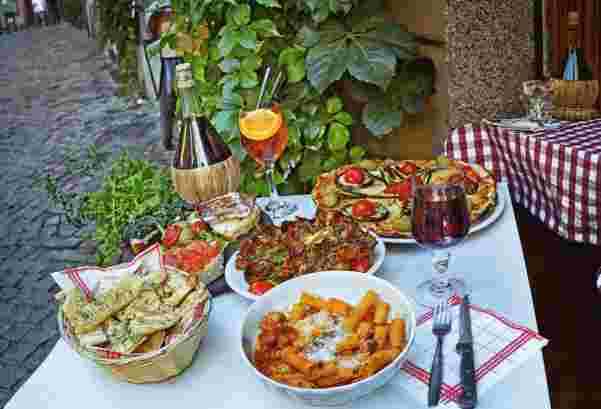 Unidentified people eating traditional italian food in outdoor restaurant