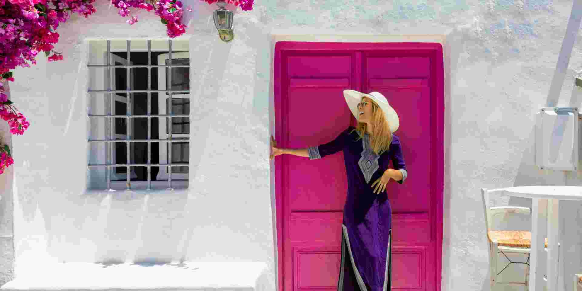 Attractive, blonde traveler woman in front of a traditional cylcadic house on the island of Paros, Naoussa, Greece Naousa Paros_How to dress in Greece_feature