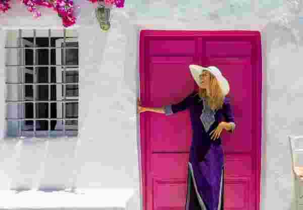Attractive, blonde traveler woman in front of a traditional cylcadic house on the island of Paros, Naoussa, Greece Naousa Paros_How to dress in Greece_feature