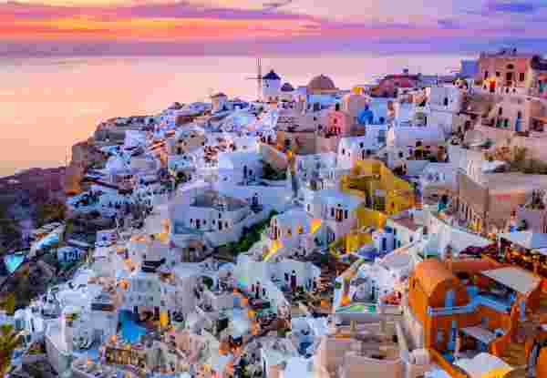 Oia town on Santorini island, Greece. Traditional and famous houses and churches with blue domes over the Caldera, Aegean sea Santorini_feature