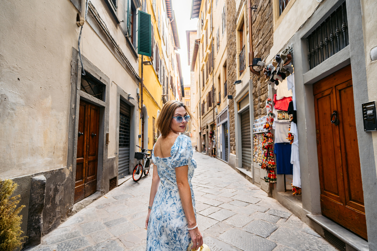 Portrait of a mid-adult woman walking in an alley in Florence in Italy.