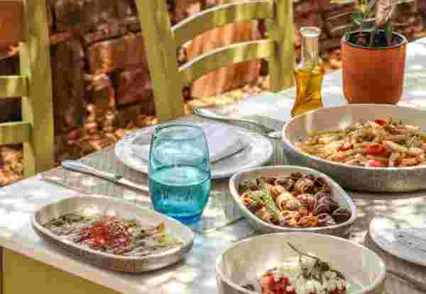Greek Dinner Table with Food and Plates under olive trees with Cretan delicacies crete for seniors_feature