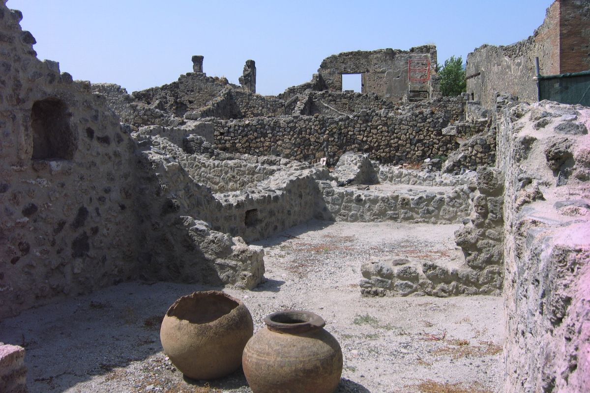 Ancient ruins and clay storage vessels in Pompeii, showcasing Roman architecture and pottery.