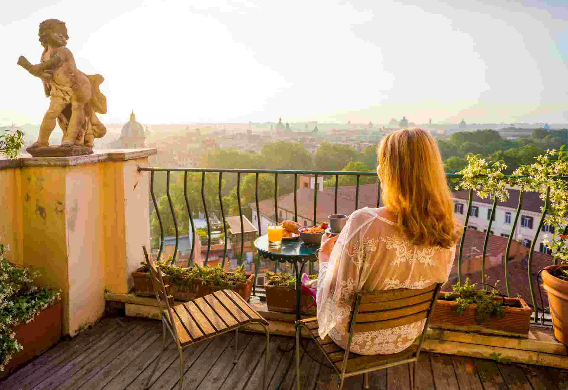 Woman sitting on balcony in early morning