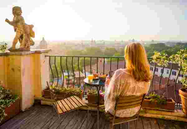 Woman sitting on balcony in early morning