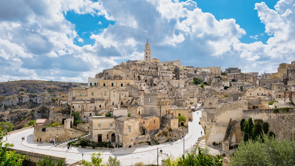 Panoramic view of Matera’s ancient stone dwellings and historic Sassi district under dramatic skies