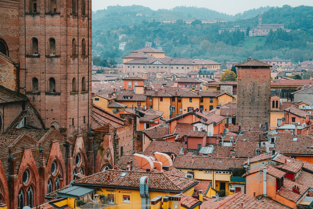Historic rooftops and medieval towers of Bologna viewed from above on a misty day