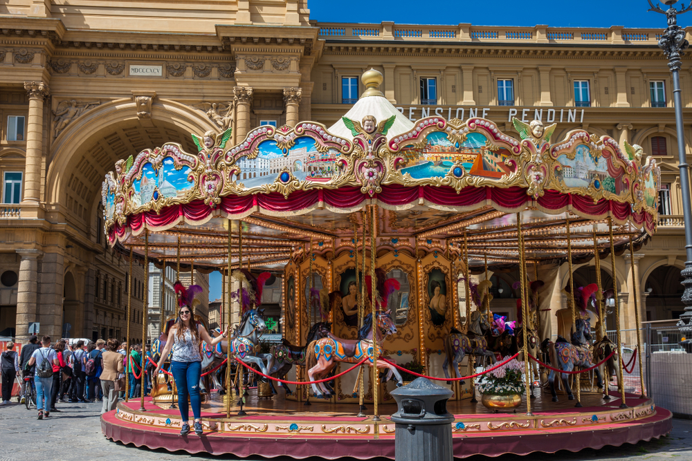Historic carousel in Piazza della Repubblica with visitors enjoying a family-friendly attraction in Florence 