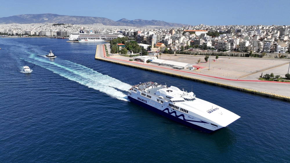Piraeus, Attica | Greece - May 05 2024: Aerial drone photo of high speed Seajet passenger vessel leaving port of Piraeus to Aegean Cycladic island destination
