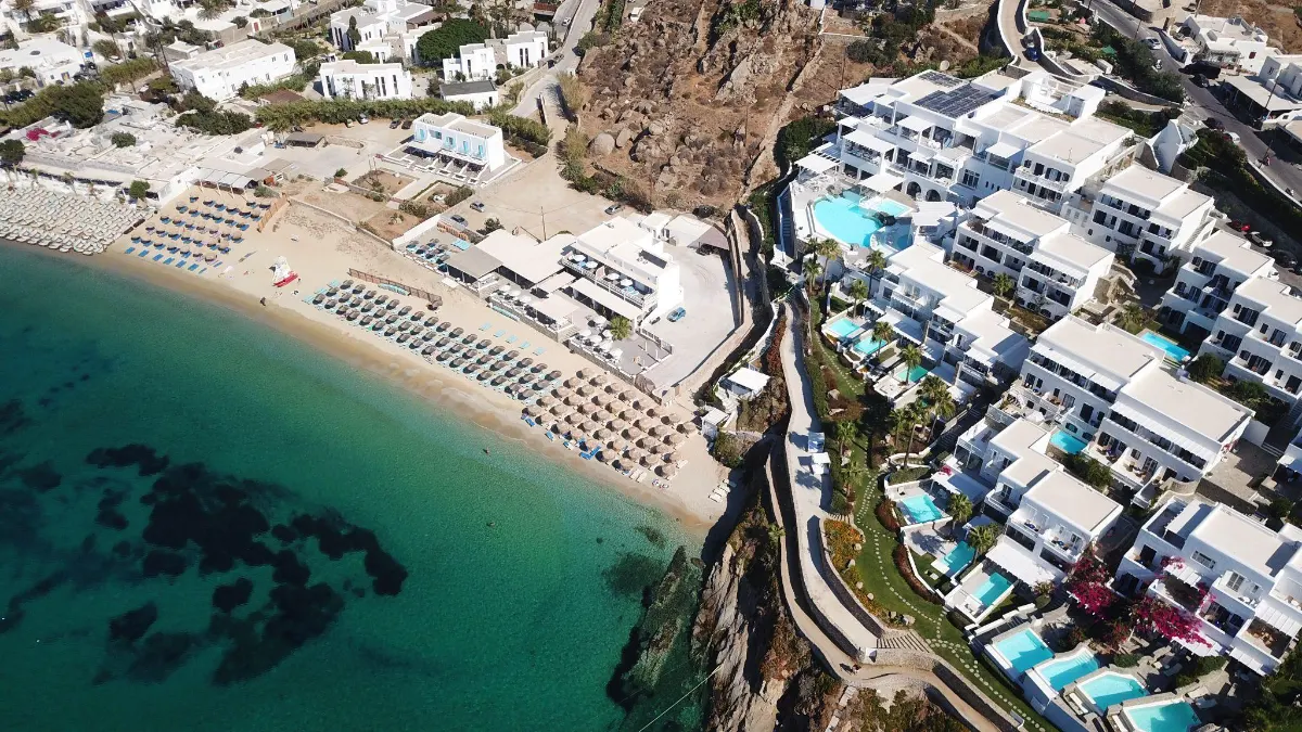 Aerial view of a Mykonos beachfront resort with pools and sun loungers Psarou Beach Mykonos 1