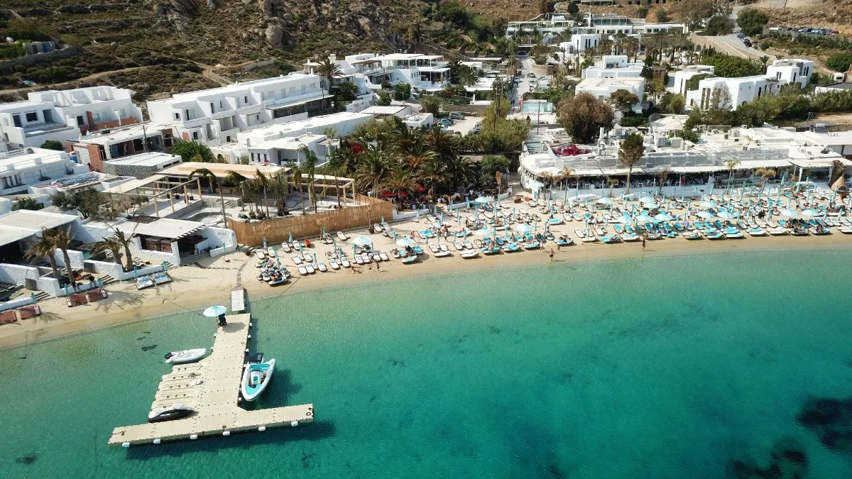 Aerial view of a beach club with turquoise loungers and a floating dock